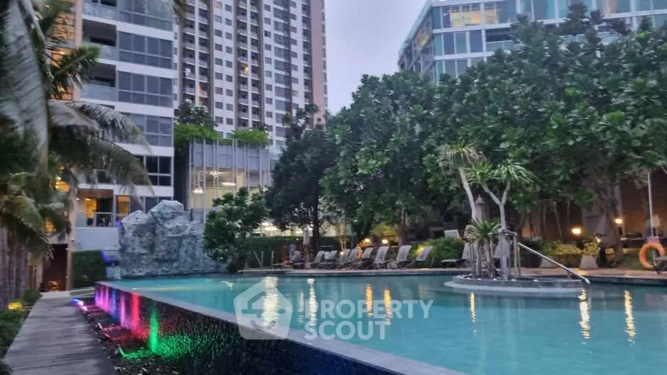 Luxurious residential pool area with modern high-rise buildings and lush greenery.