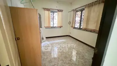 Spacious bedroom with tiled floor and large windows for natural light.