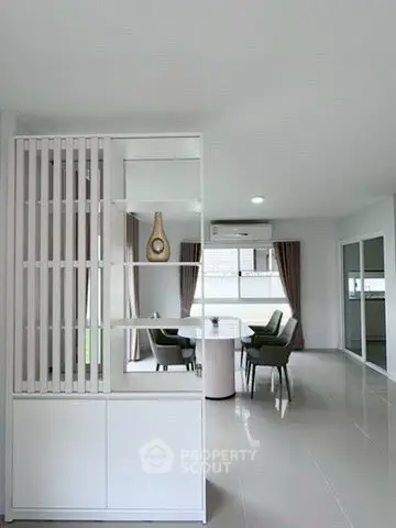 Modern open-plan living room with sleek furniture and large windows.