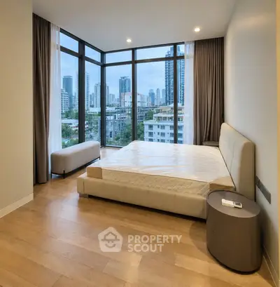 Spacious bedroom with panoramic city views and modern furnishings in a luxury apartment.
