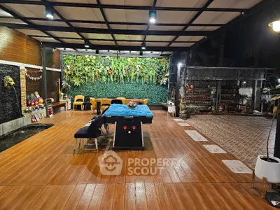 Luxurious outdoor patio with pool table and lush greenery, perfect for entertainment and relaxation.