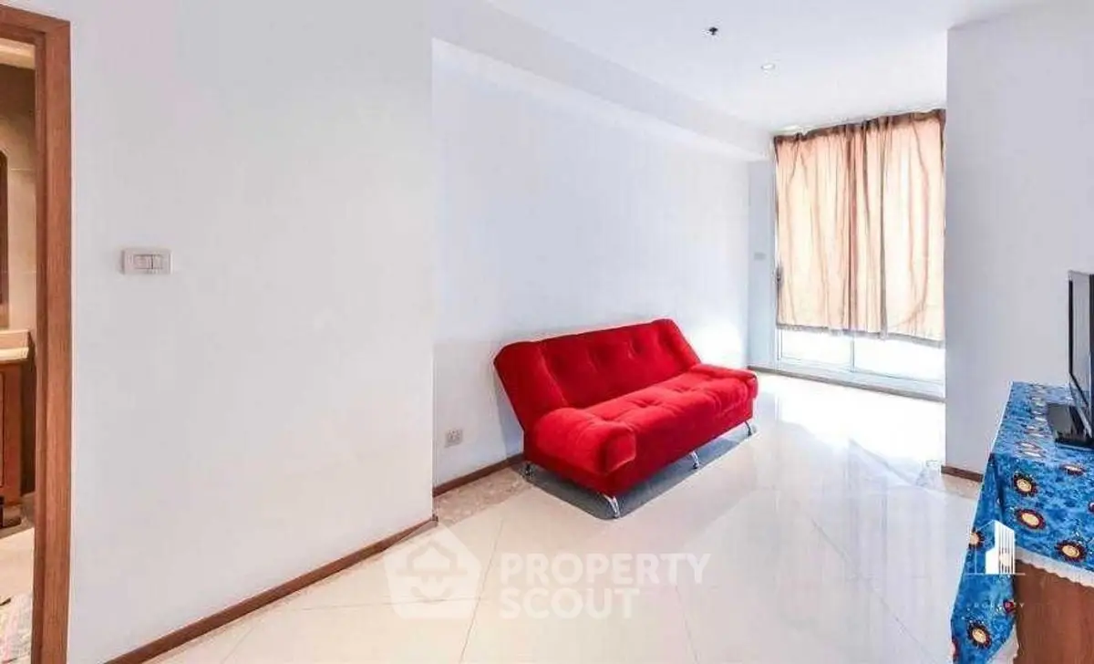 Bright living room with red sofa and natural light, perfect for relaxation.