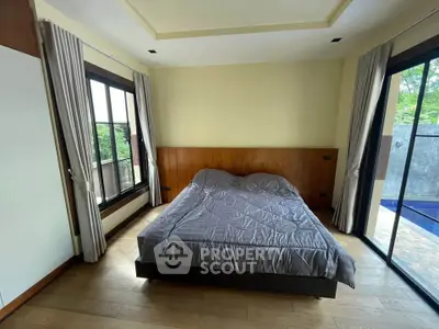 Spacious bedroom with pool view and elegant wooden flooring