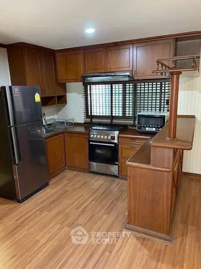 Spacious kitchen with wooden cabinets and modern appliances in a cozy home setting.