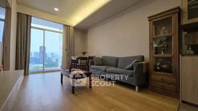 Spacious living room with modern decor and city view, featuring a cozy sofa and elegant wooden furniture.
