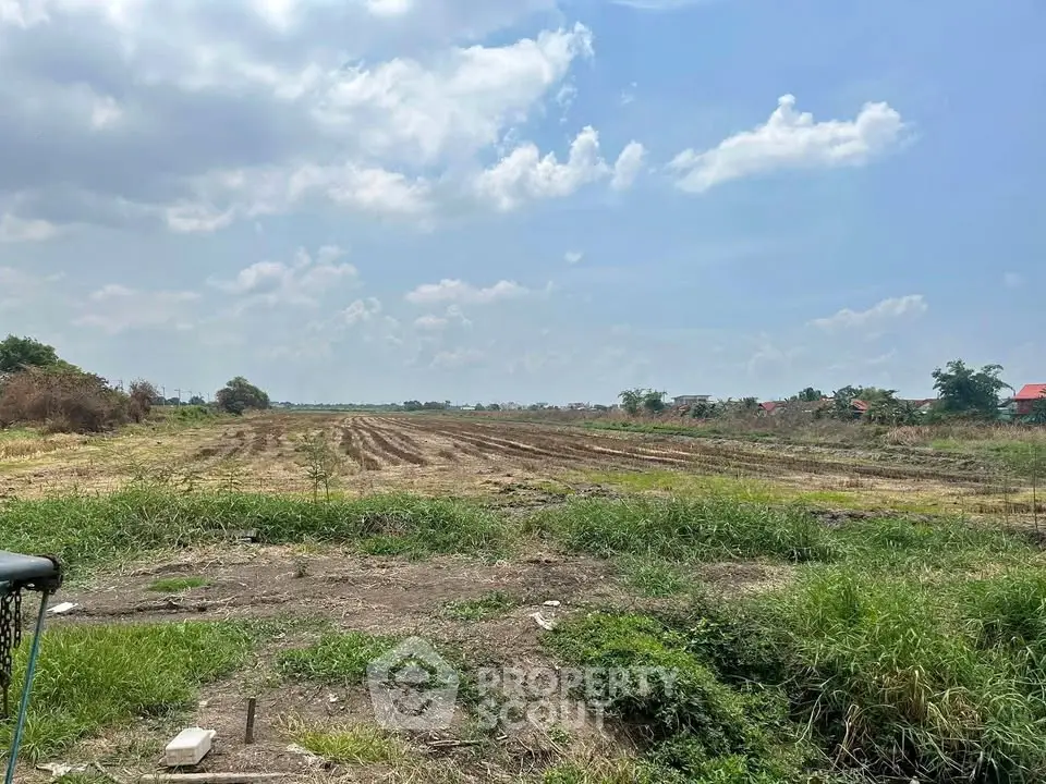Expansive vacant land under a clear blue sky, ideal for development opportunities.