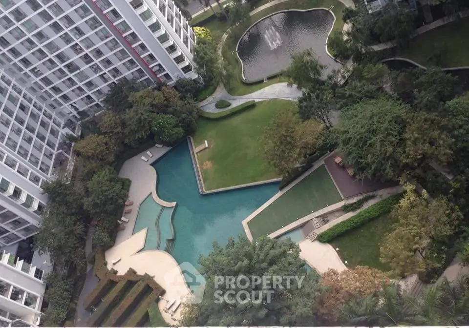 Stunning aerial view of modern apartment complex with pool and lush gardens.