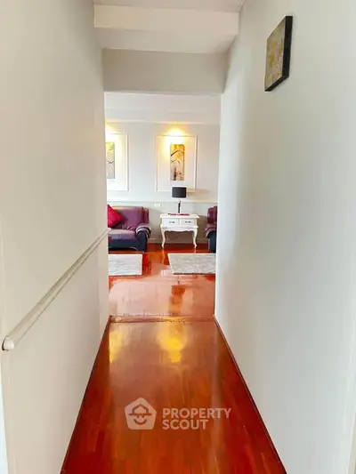 Elegant hallway leading to a cozy living room with stylish decor and wooden flooring.