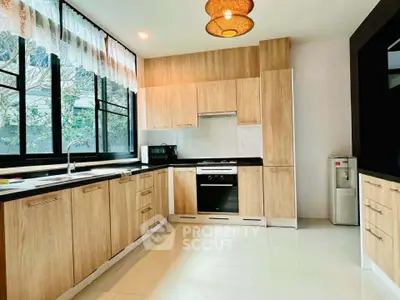 Spacious modern kitchen with wooden cabinets and large windows