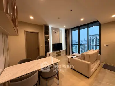 Modern living room with city view, featuring elegant furniture and open layout.