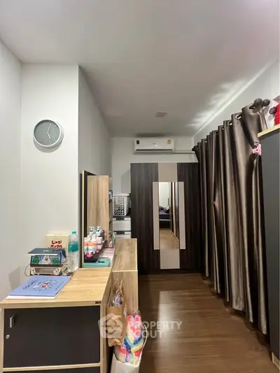 Modern bedroom with sleek furniture and air conditioning, featuring a stylish wardrobe and elegant curtains.