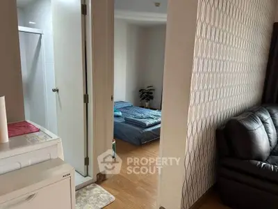 Cozy apartment interior with bedroom and living area, featuring modern decor and wooden flooring.