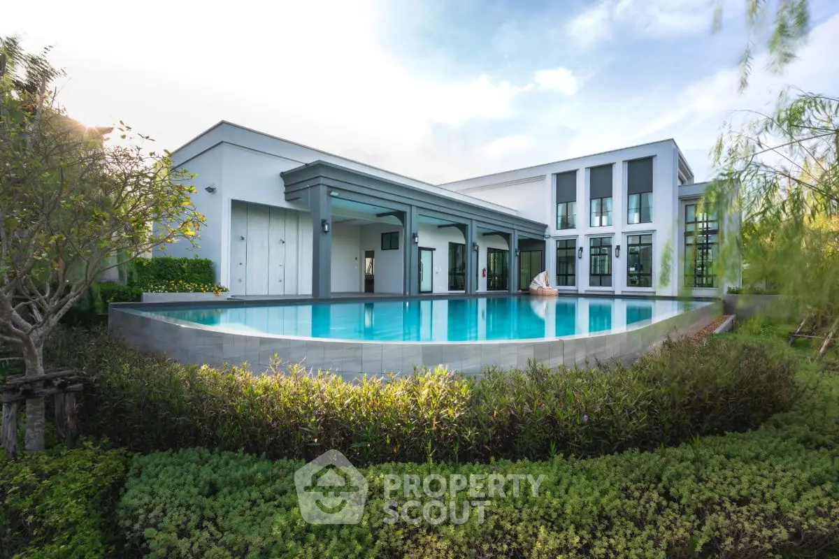 Luxurious modern home with stunning pool and lush garden, perfect for serene living.