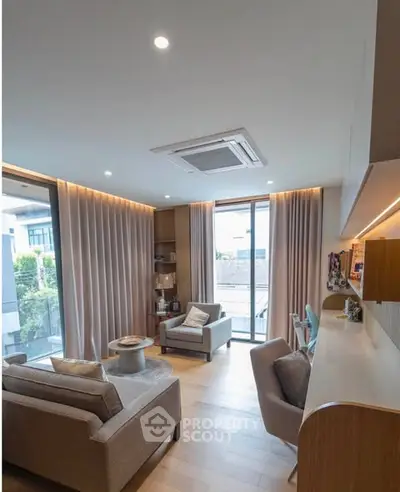 Modern living room with elegant decor and large windows offering natural light.