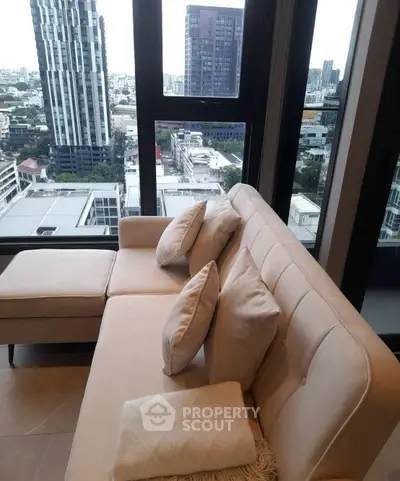 Stylish living room with modern sofa and panoramic city view from high-rise apartment.