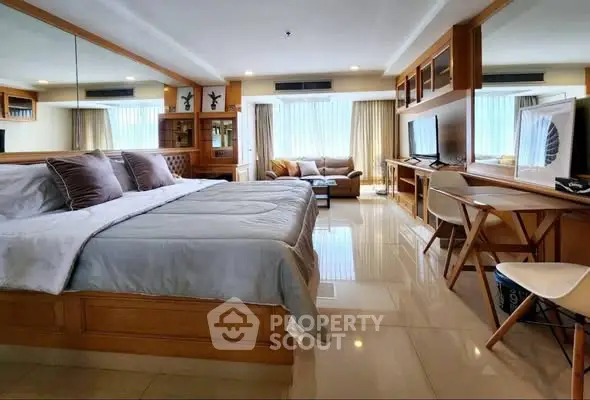 Spacious bedroom with modern decor and large windows for natural light.