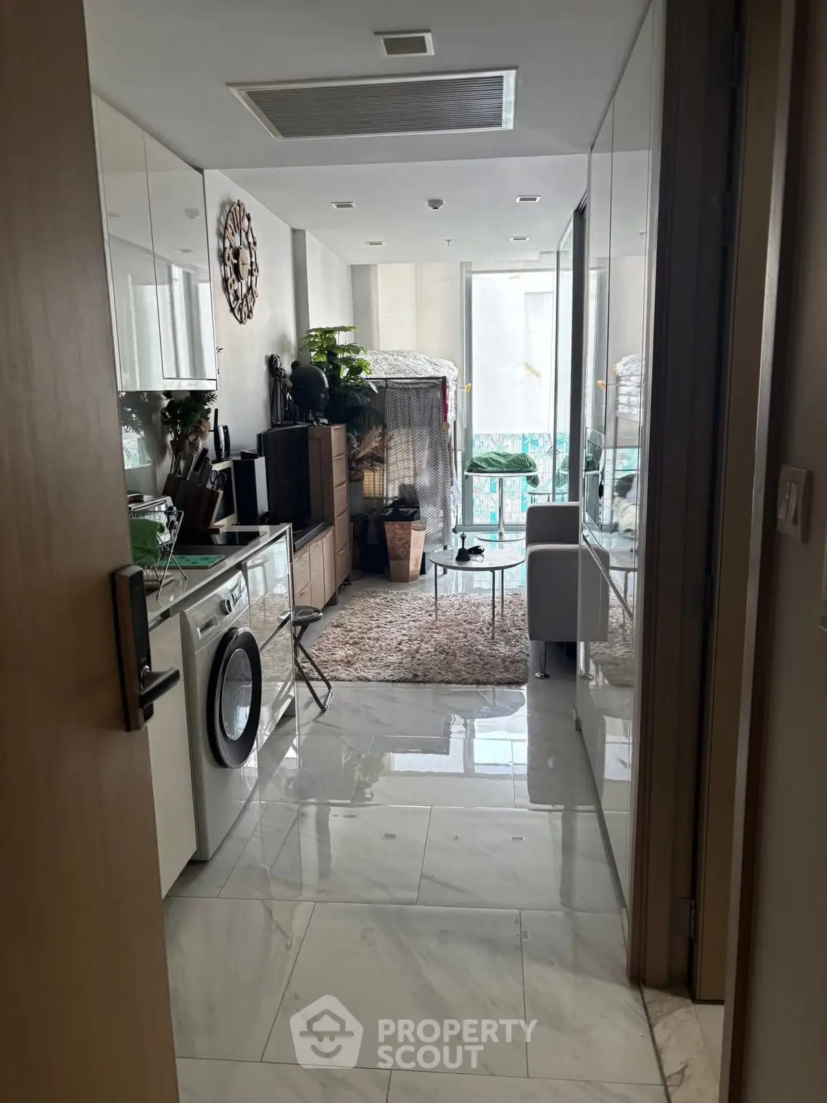 Modern apartment interior with washing machine and balcony view