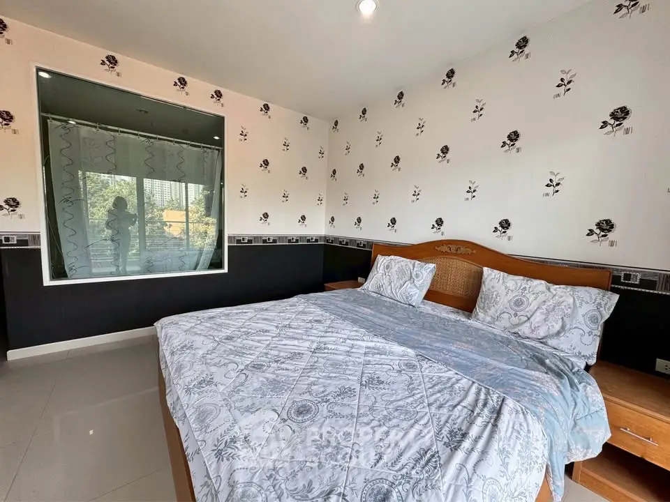 Spacious bedroom with elegant floral wallpaper and large bed, offering a cozy and inviting atmosphere.