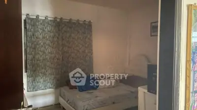 Cozy bedroom with patterned curtains and a comfortable bed, ideal for relaxation.