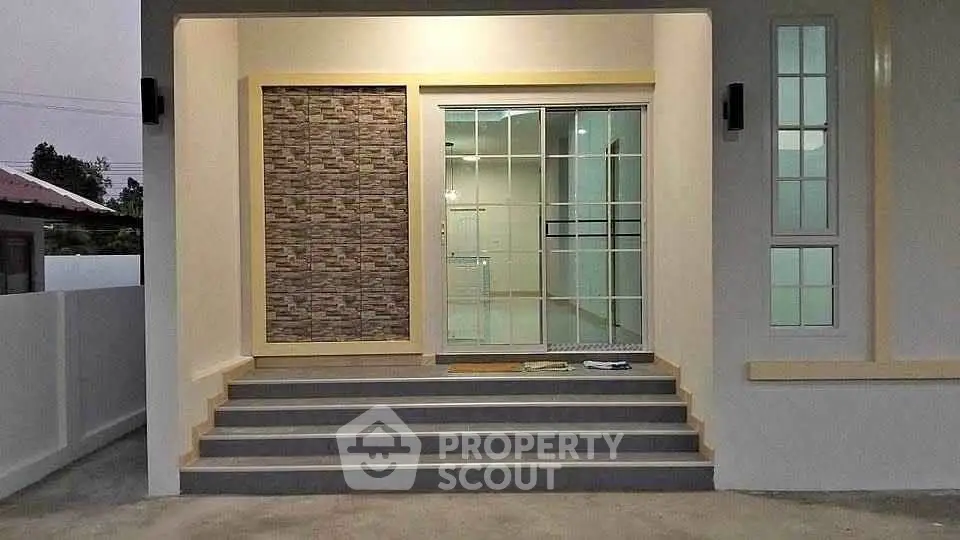 Modern home entrance with stylish stone accent wall and glass door