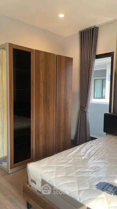 Modern bedroom with wooden wardrobe and large window for natural light