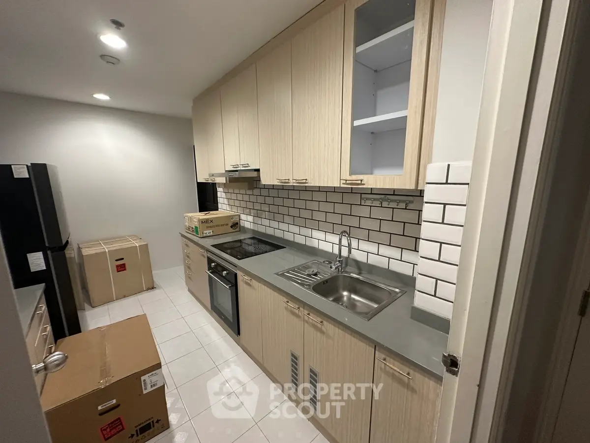 Modern kitchen with sleek cabinetry and stainless steel appliances in a stylish apartment.