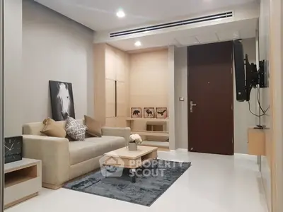 Modern living room with stylish decor and wall-mounted TV in a cozy apartment.