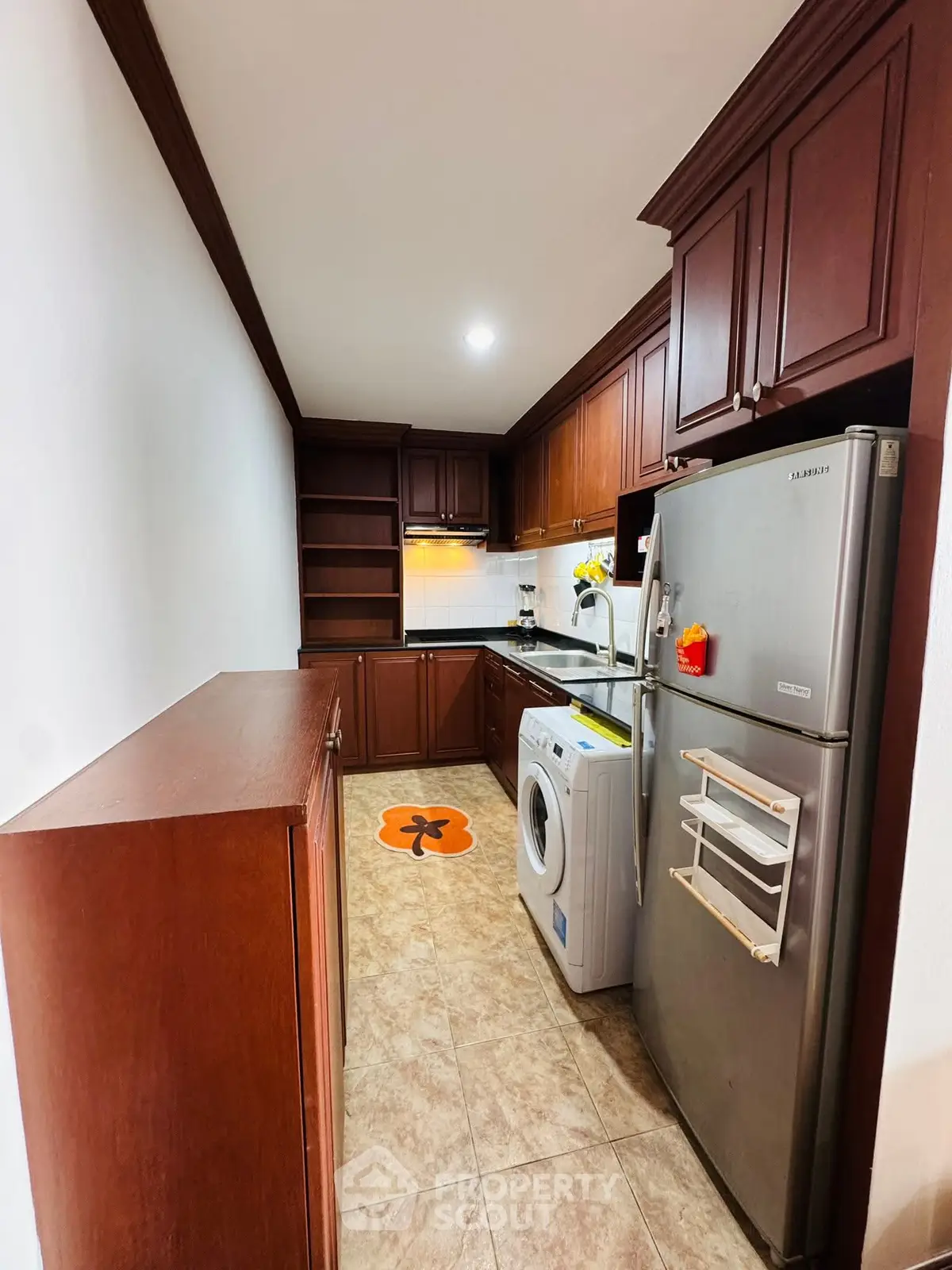 Charming kitchen with wooden cabinets, modern appliances, and tiled flooring.