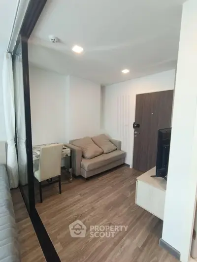 Modern living room with cozy seating and wooden flooring in a stylish apartment.