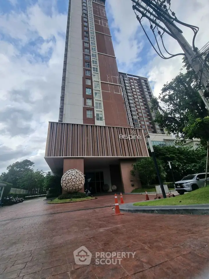 Modern high-rise building with stylish entrance and landscaped surroundings.