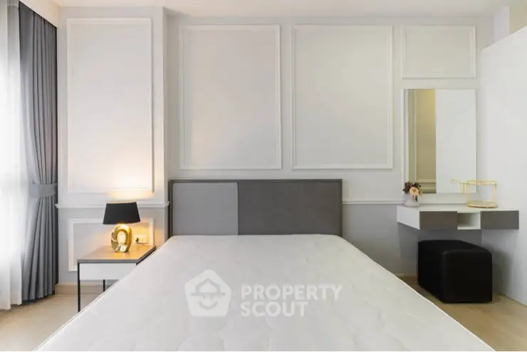 Modern bedroom with stylish decor and natural light, featuring a comfortable bed and elegant furnishings.