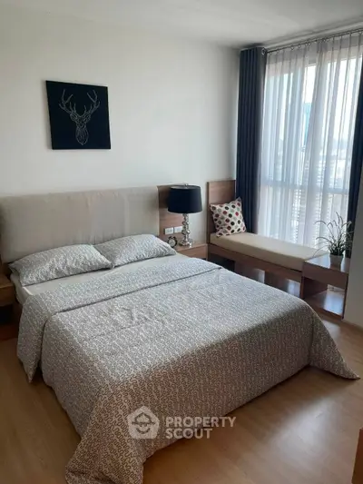 Modern bedroom with stylish decor and natural light, featuring a cozy bed and elegant furnishings.