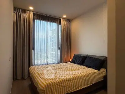 Cozy bedroom with large window and modern decor in high-rise apartment
