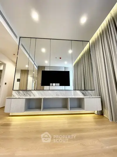 Modern living room with sleek TV unit and mirrored wall design
