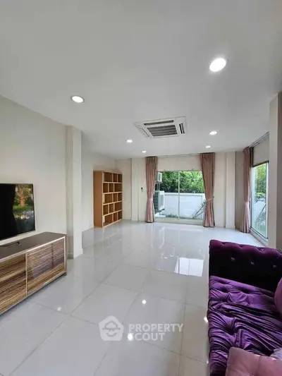 Spacious living room with modern decor and large windows offering natural light.