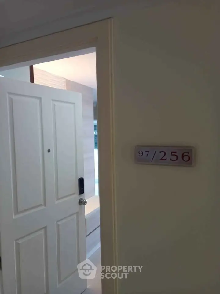 Modern apartment entrance with partially open door revealing interior