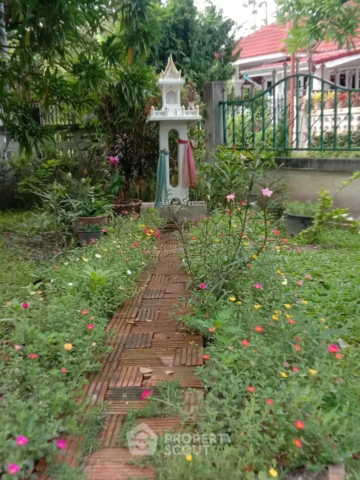 Charming garden with vibrant flowers and a decorative shrine, perfect for serene outdoor living.
