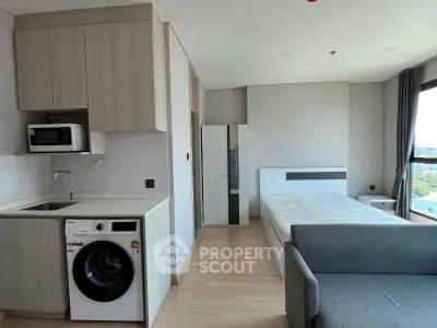 Modern studio apartment with kitchen and laundry facilities, bright and spacious layout.