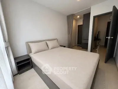 Modern bedroom with minimalist design and neutral tones, featuring a comfortable bed and sleek furniture.
