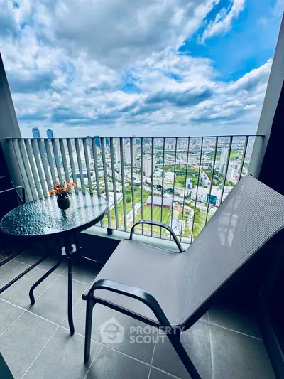 Stunning high-rise balcony with panoramic city views and cozy seating area.