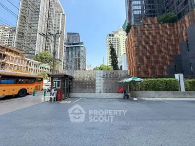 Modern urban building entrance with high-rise towers and cityscape view.