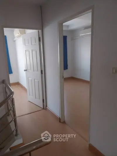 Spacious interior hallway with wooden flooring and natural light, ideal for modern living.