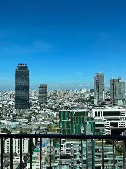 Stunning cityscape view from a high-rise balcony with clear blue skies.