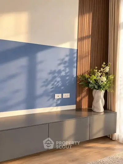 Modern interior with stylish console and decorative vase in sunlit room.