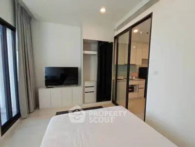 Modern bedroom with sleek design and open kitchen view in luxury apartment