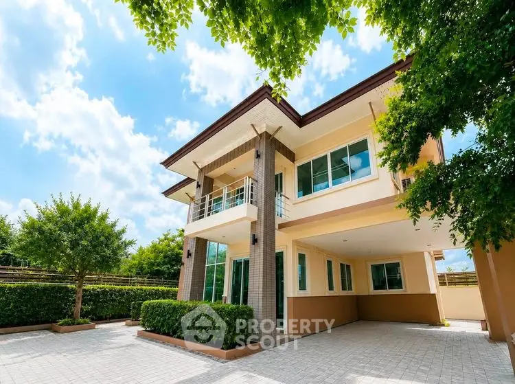 Stunning modern two-story house with lush greenery and spacious driveway.