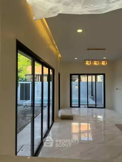 Modern living room with large windows and marble flooring