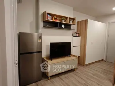 Modern living room with sleek fridge, TV unit, and stylish storage cabinets.