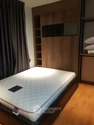 Modern bedroom with stylish wooden accents and comfortable mattress, perfect for a cozy retreat.