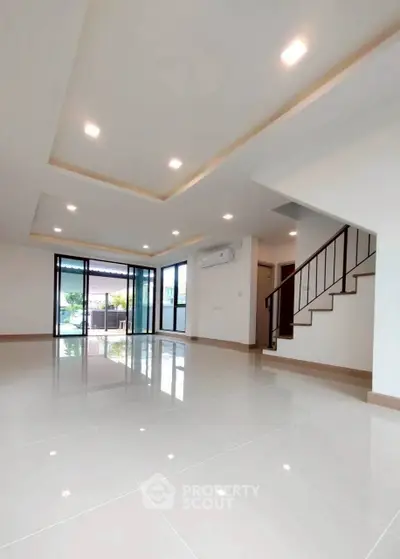 Spacious modern living room with sleek tile flooring and large windows for natural light.